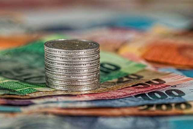 Stack of coins on colorful banknotes, symbolizing financial stability, credit management, and improving credit scores