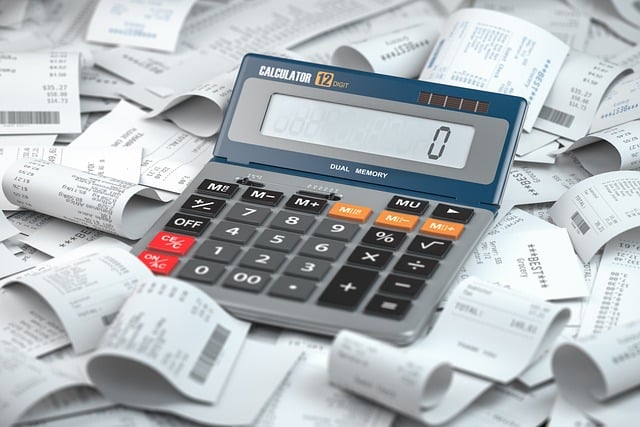 Calculator placed on a pile of receipts, symbolizing budgeting, financial management, and tracking expenses effectively