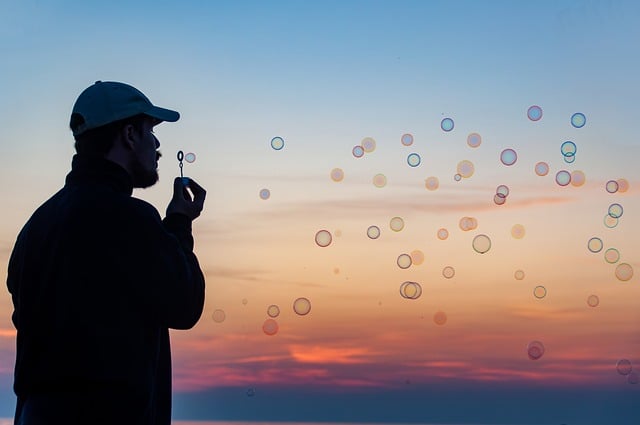 Silhouette of a person blowing bubbles during sunset, symbolizing relaxation, mindfulness, and achieving work-life balance