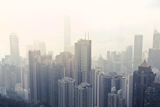 City skyline shrouded in dense smog, highlighting the effects of air pollution on urban areas and the need for sustainable solutions.