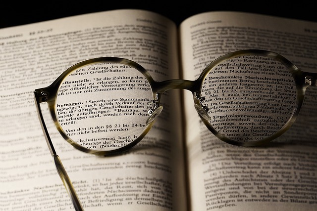 Round eyeglasses placed on an open book with text in focus through the lenses, symbolizing clarity and enhanced reading comprehension.